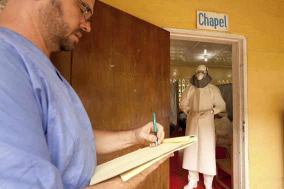 Dr. Kent Brantly (R) of Samaritan's Purse relief organization is shown in this undated handout photo provided by Samaritan's Purse, wearing personal protective equipment as he gives orders for medication to the Ebola patients through the doorway of the isolation unit at the case management center on the campus of ELWA Hospital in Monrovia, Liberia.   REUTERS-Samaritan's Purse-Handout via Reuters